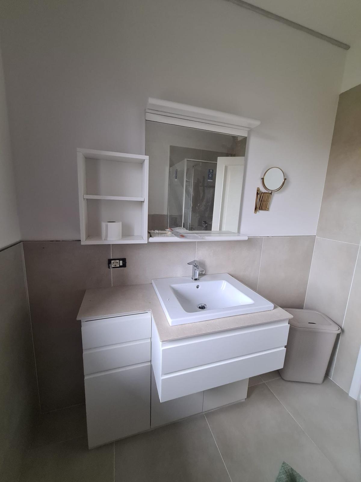 Mobile bagno bianco con lavabo singolo e specchio