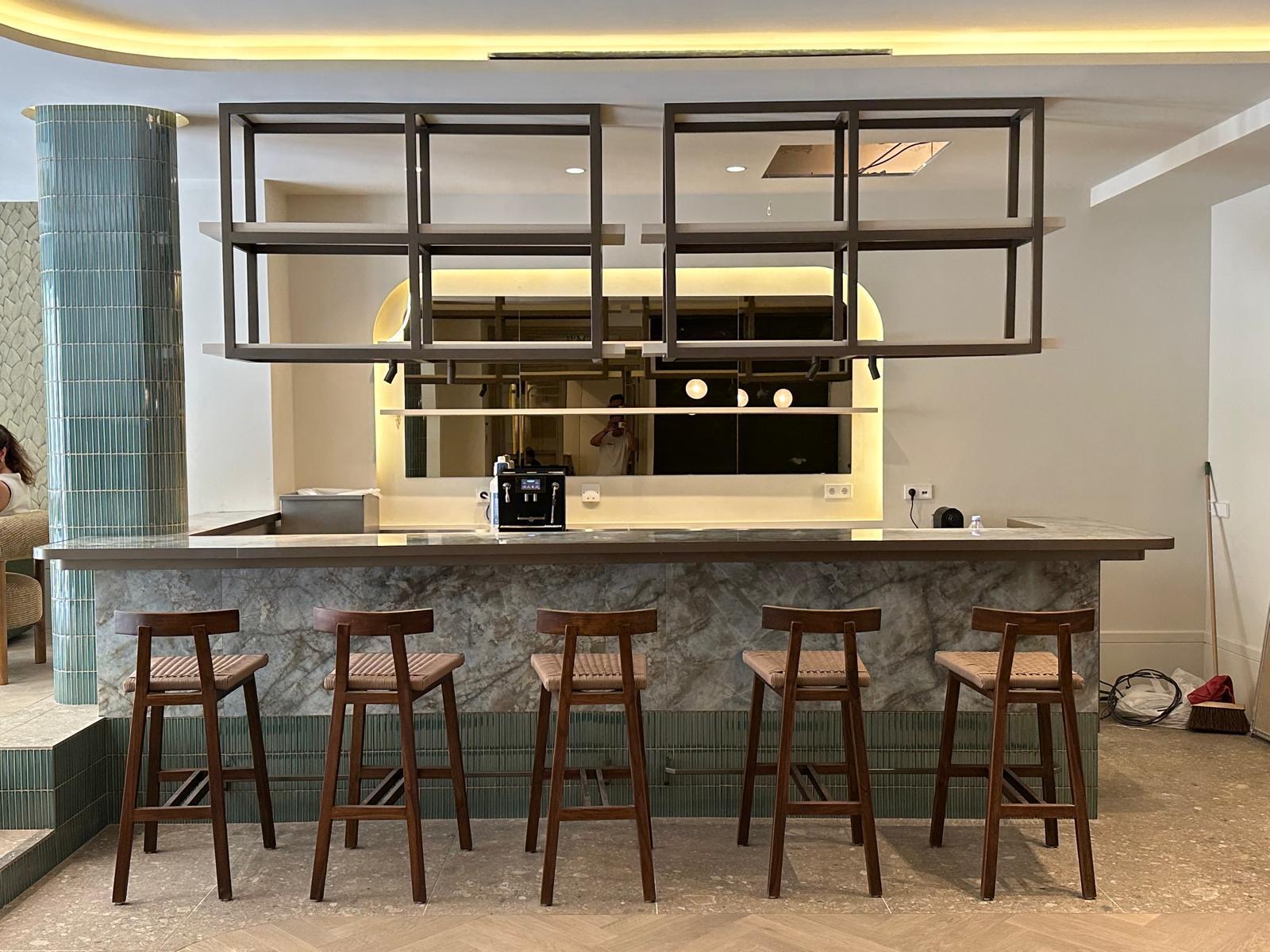 Bancone bar con scaffalature metalliche e top in marmo