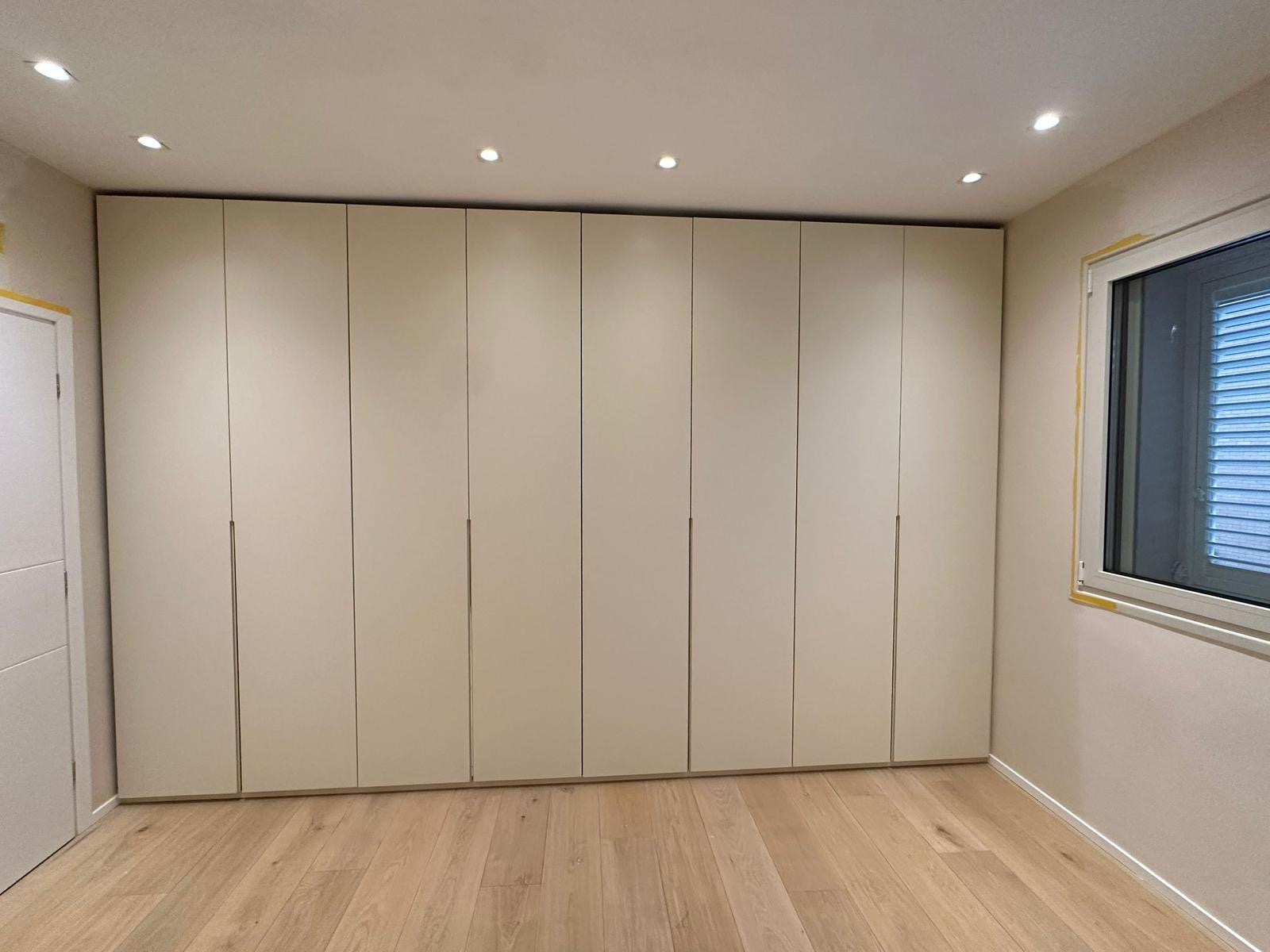 Armadio a parete intera con otto ante bianche