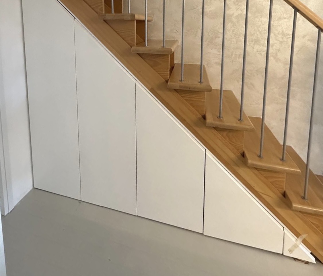 Scala in legno con armadi bianchi sottoscala
